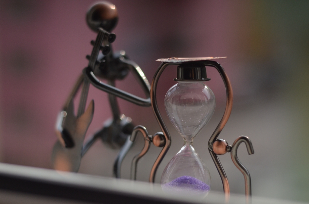 Kum saati ve gitar alan adam